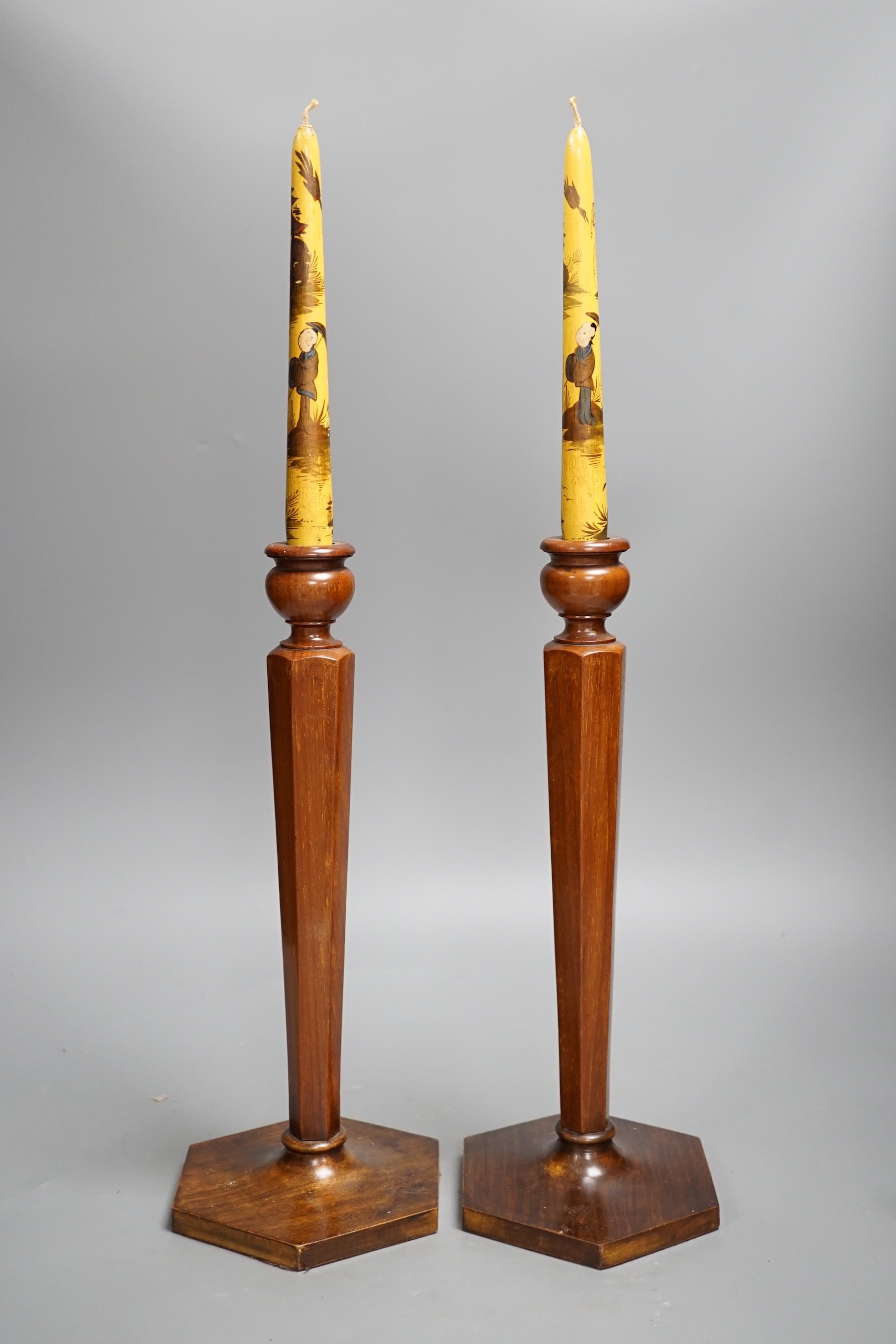 A pair of hexagonal fruitwood candlesticks with chinoiserie faux candles and two volumes on Japanese and Chinese art, candlesticks 53cms high